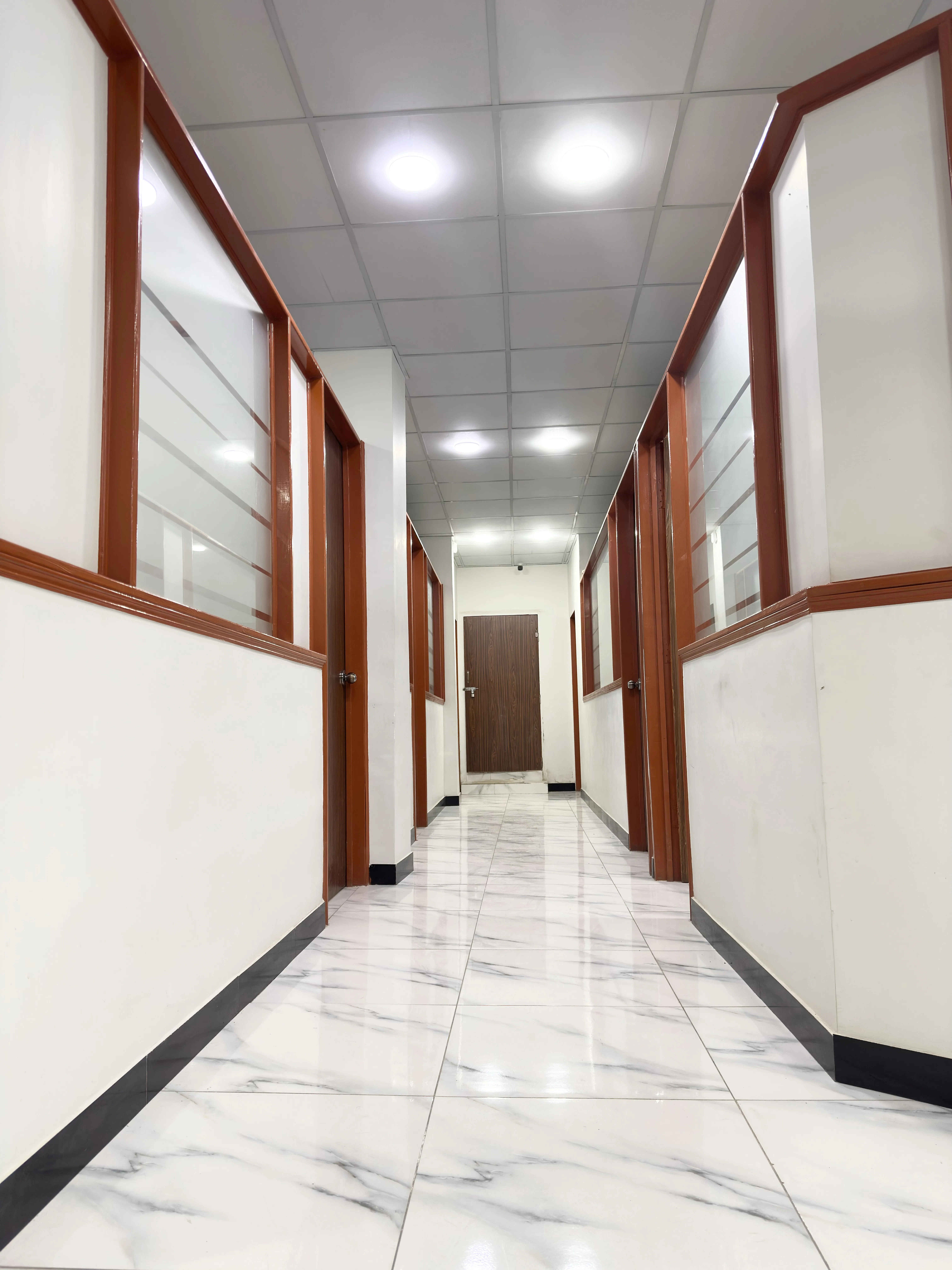 Interior corridor at Apex Corporation knitwear manufacturer office in Karachi Pakistan showing glass partitioned work areas